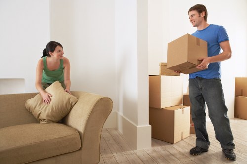 Local movers organizing packed boxes for a flat in Old Oak Common